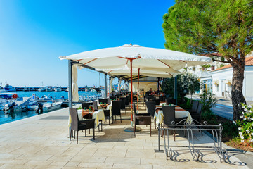 Sidewalk street cafe near Adriatic Sea and Marina of Izola
