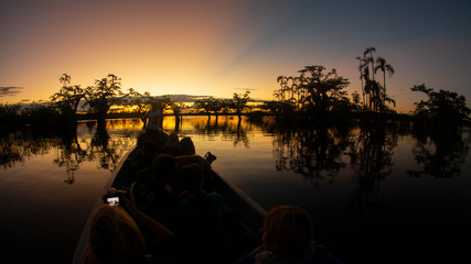 Tourists traveling by canoe on a lagoon in the Amazon while taking sunset photos © alejomiranda