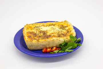 Cheese pie with parsley on a blue plate