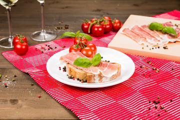 Plentiful table with bread, ham, white wine, tomatoes and ingredients