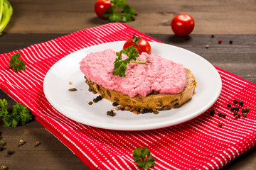 Sandwich with pink paste and tomato on the plate 