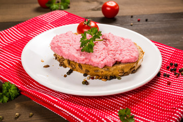 Sandwich with pink paste and tomato on the plate 