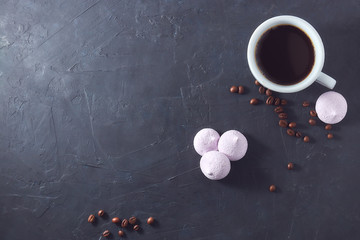 Morning aromatic coffee with baked meringue, on black concrete. view from above. Copy space. scattered coffee beans. space for advertising.