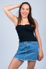 Young happy multi-ethnic woman smiling while brushing hair back