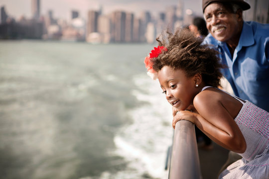 Smiling girl with grandfather travelling in ferry