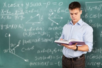 Young male teacher   standing with book