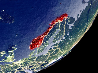 Norway from space on model of Earth at night. Very fine detail of the plastic planet surface and visible bright city lights.