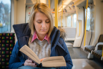 Woman reading book on a train