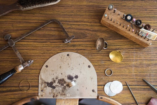 Overhead view of work tools with ring on wooden workbench in workshop