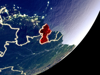 Guyana from space on model of Earth at night. Very fine detail of the plastic planet surface and visible bright city lights.