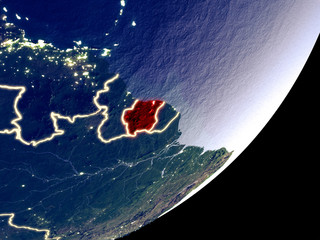 Suriname from space on model of Earth at night. Very fine detail of the plastic planet surface and visible bright city lights.