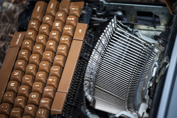 Old and broken typewriter, obsolete, with the blades and the QWERTY keyboard remaining following...