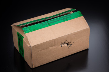 Kaputtes Paket - Zerstörte braune Versandverpackung beim Onlineshopping