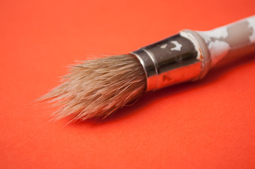 closeup of paint brush on orange background