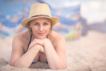 Beautiful woman with a wicker hat on the beach