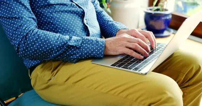 Casual Businessman Sitting On Chair And Typing On Laptop
