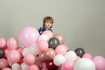 Fototapeta na wymiar Birthday party. Air balloons for a party. Peekaboo, hide and seek game. Bo peep, hy spy. The child is played and hides behind the balls. Kids toys. Movement and play. Children's activity