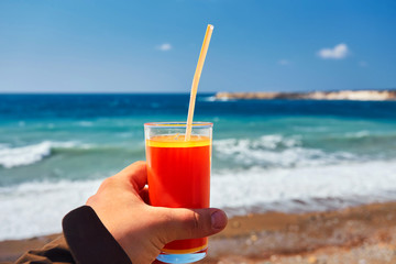 fresh drink in man's hand on the background of the exotic beach