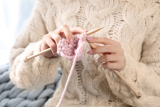 Beautiful teenage girl in warm cozy sweater knitting, closeup