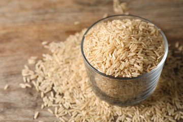 Brown rice in glass on table. Space for text