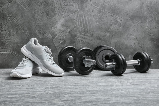 Composition with dumbbells and fitness accessories on floor. Space for text
