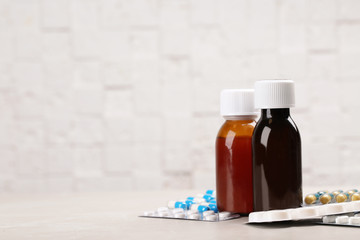 Syrups and different cough remedies on table. Space for text