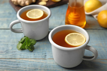 Obraz na płótnie Canvas Cups of hot lemon tea as cough remedy on wooden table