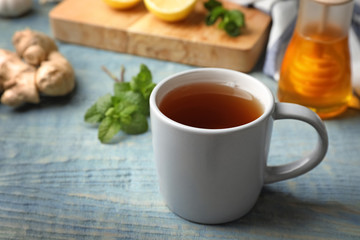Cup of hot tea as natural cough remedy on wooden table