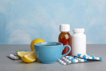 Cup of hot tea and different cough remedies on table
