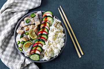 Poke bowl with herring, rice and vegetables. Herring poke bowl. Colorful healthy food.