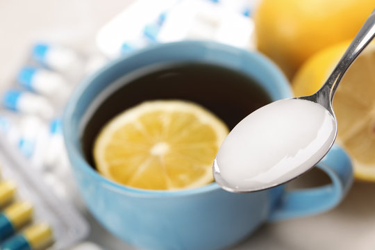 Spoon with cough syrup on blurred background, closeup