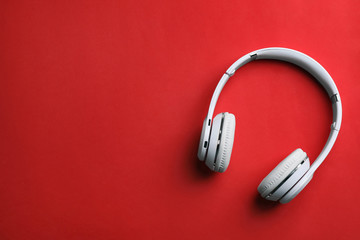 Wireless headphones on color background, top view. Space for text