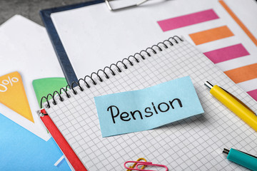 Paper with word PENSION and stationery on notebook page