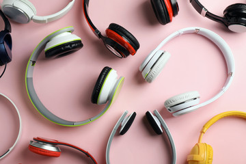 Many different headphones on color background, top view