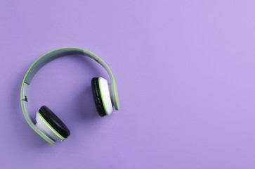 Wireless headphones on color background, top view. Space for text