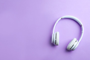 Wireless headphones on color background, top view. Space for text