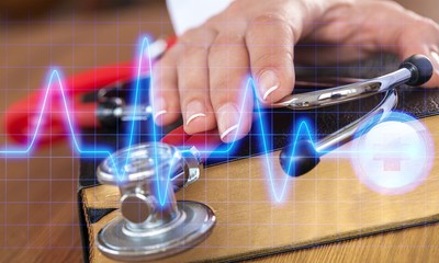 hand with stethoscope on top of old book