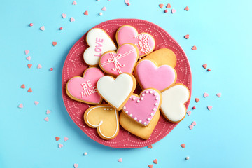 Composition with decorated heart shaped cookies on color background, top view