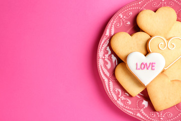 Obraz premium Plate with decorated heart shaped cookies and space for text on color background, top view. Valentine's day treat