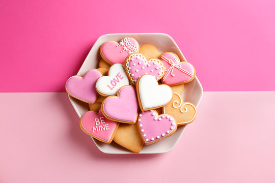 Plate with decorated heart shaped cookies on color background, top view. Valentine's day treat