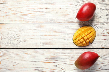 Flat lay composition with mango on white wooden background. Space for text
