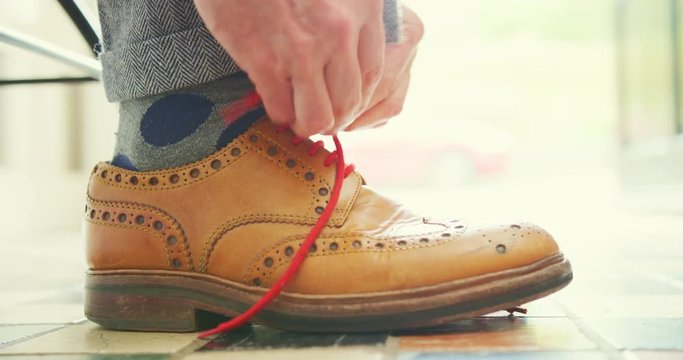 Closeup Of Man Tying The Lace On Tan Brogues 4K