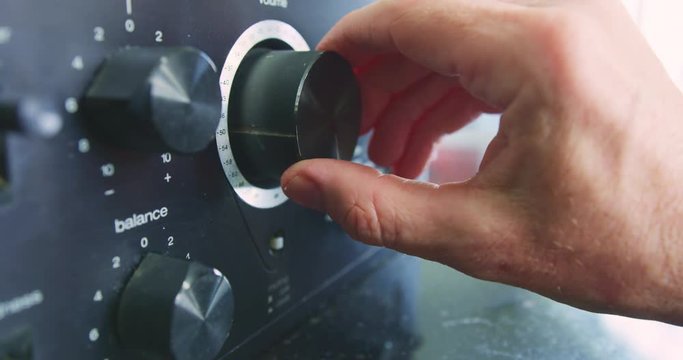 Closeup Of Hand Turning The Volume Knob Of Amplifier 4K