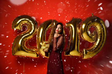 Woman celebrating New Year party happy laughing with Christmas 2019 gold balloons