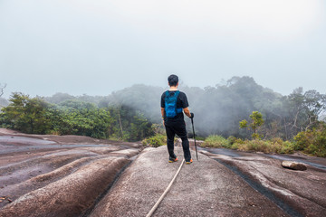 Mount Ledang Trail, Johor, Malaysia. Men hiking and Rock climbing. Selective focus
