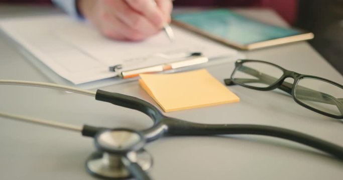 Doctor With Digital Tablet Filling RX Prescription At Desk 4K