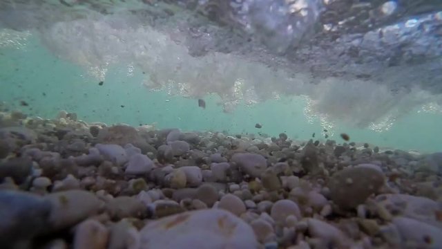 Sea rocks in water under wave
