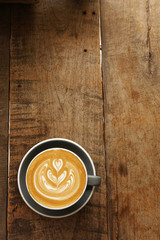 a cup of latte art coffee on wooden background