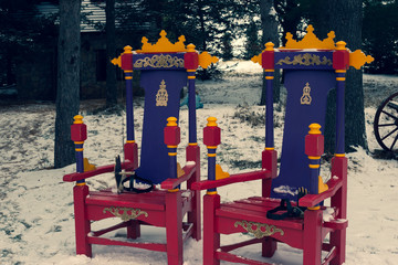 The king and queesn’s chairs outside in the snow.