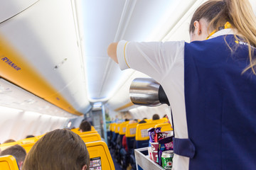 Valencia, Spain - Dec 14, 2017: Interior view of stewardess serving passangers on Ryanair low-cost flight on 14th of December, 2017 on a flight from Trieste to Valencia.